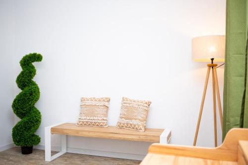 a living room with a bench with a green plant at Maier Apartment Cisnadie in Cisnădie