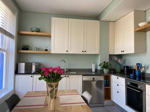 a kitchen with a table with a vase of flowers on it at Modern city townhouse with rooftop terrace in Cape Town
