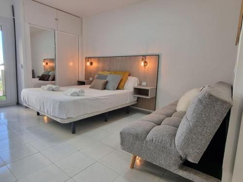 a bedroom with a large bed and a couch at Jupiter2 Moderno estudio Parque La Paloma in Benalmádena