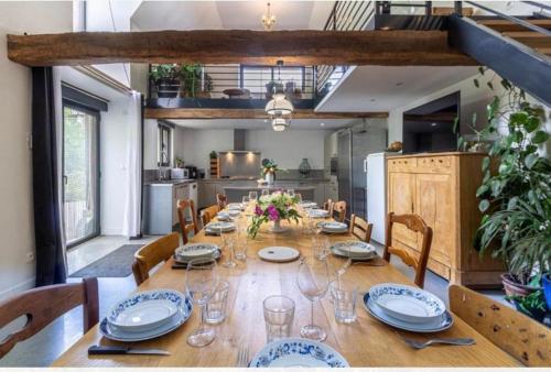 une salle à manger avec une grande table, des assiettes et des verres à vin dans l'établissement Villa de Lurp panorama spa 12 pers, à Saint-Pastous