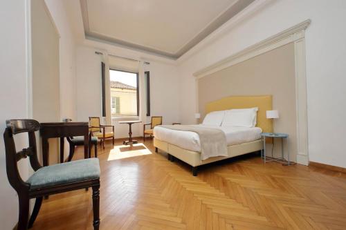 ein Schlafzimmer mit einem Bett, einem Schreibtisch und einem Klavier in der Unterkunft Spanish Steps Family Home by TreasureRome in Rom