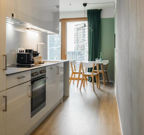 a kitchen with a counter and a table with chairs at Decorous cozy city view suite in Vienna