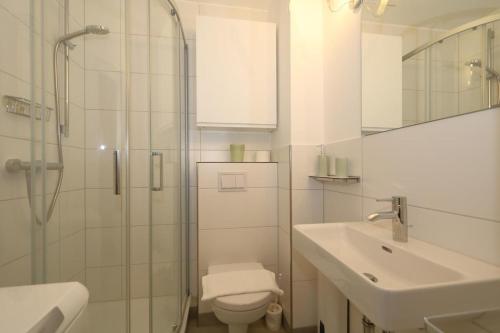 a bathroom with a shower and a toilet and a sink at Haus Wattblick Meier W.O. in Braderup