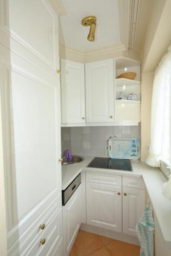 eine weiße Küche mit weißen Schränken und einem Waschbecken in der Unterkunft Haus Alice - Becker 36/10 in Westerland