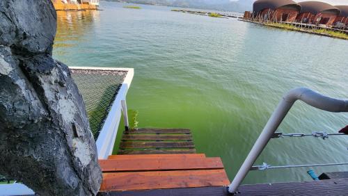 a group of stairs leading into a body of water at บ้านไร่ วรรณ วาลย์ รีสอร์ท in Tha Kradan