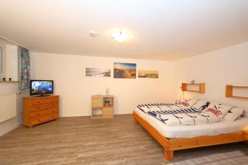 1 dormitorio con 1 cama y TV en Südstrand 11 en Westerland