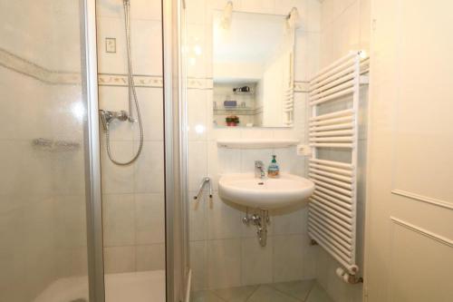 y baño blanco con lavabo y ducha. en Südstrand 11 en Westerland