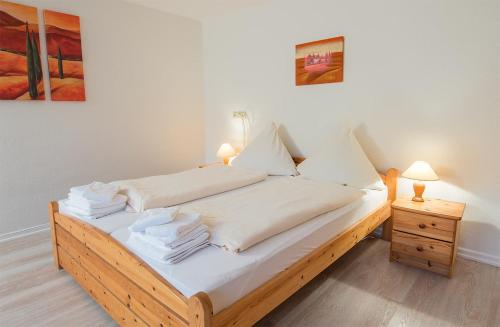 Schlafzimmer mit einem Bett mit weißer Bettwäsche und Kissen in der Unterkunft Südstrand 3 in Westerland