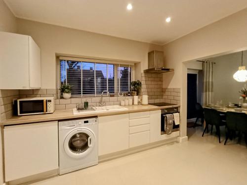 a kitchen with a washing machine and a microwave at The Tansley Gardens in Darlington