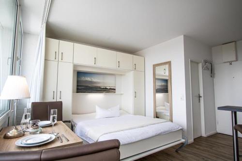- une chambre avec un lit, une table et un bureau dans l'établissement App. Preetz 32 OB, à Westerland