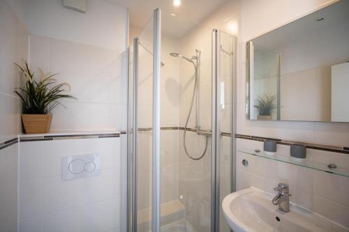 La salle de bains est pourvue d'une douche et d'un lavabo. dans l'établissement App. Preetz 32 OB, à Westerland