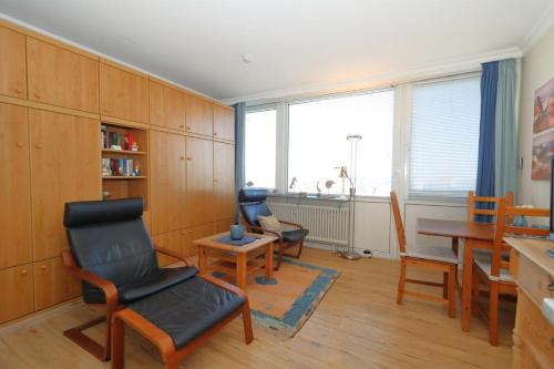 a living room with chairs and a table and a window at App. Kleinhubbert in Westerland