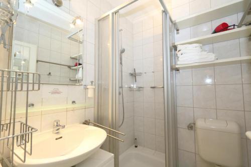 a bathroom with a shower and a sink and a toilet at App. Kleinhubbert in Westerland