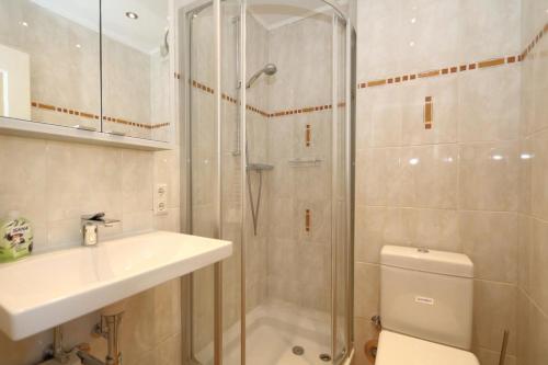 ein Bad mit einer Dusche, einem Waschbecken und einem WC in der Unterkunft Grimme 15 WB in Westerland