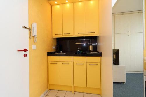 a kitchen with yellow cabinets and a sink at Löffler 6/51 in Westerland (Sylt)