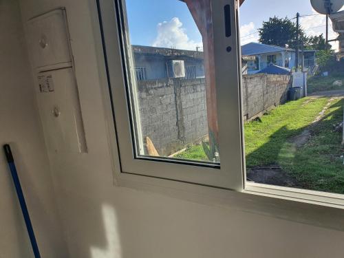 an open window with a view of a yard at Bungalow vacances in Sainte-Rose