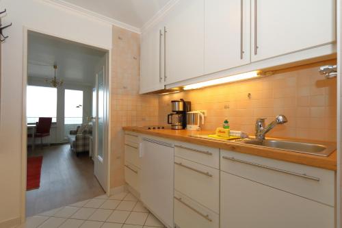 a kitchen with white cabinets and a sink at Haus am Meer14 - App. 144 WB in Westerland