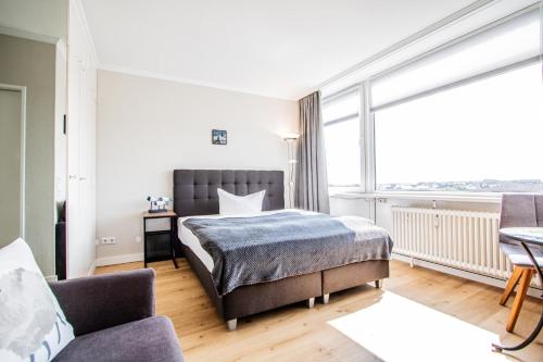 a bedroom with a bed and a large window at App. Busch 45 in Westerland (Sylt)