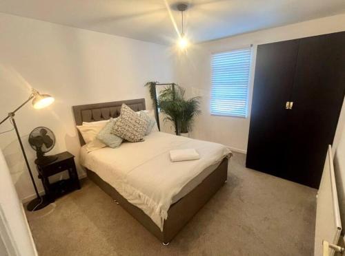 a bedroom with a bed and a window and a lamp at 4 Mellors Court in Warwick