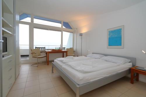 ein Schlafzimmer mit einem Bett und einem Tisch und einem Fenster in der Unterkunft Haus am Meer14 - App. 159 in Westerland