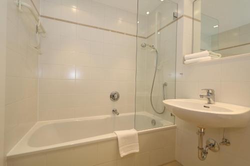 ein Bad mit einer Badewanne, einem Waschbecken und einer Dusche in der Unterkunft Haus am Meer14 - App. 159 in Westerland