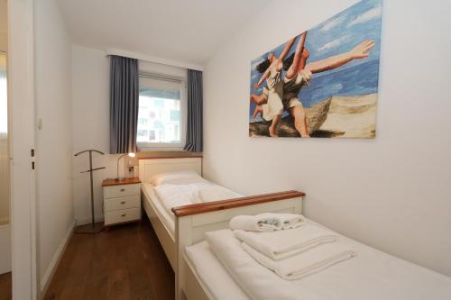 a bedroom with two beds and a painting on the wall at App. Kohfahl 65 in Westerland