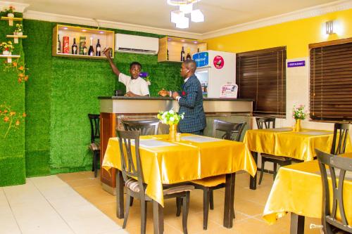 two men standing at the counter of a restaurant at Suru Express Hotel in Suru Lere