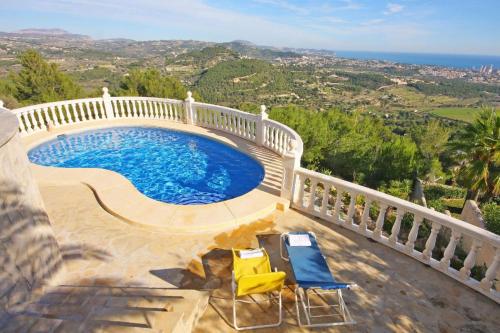 a swimming pool on a balcony with two chairs at Villa Lehman - PlusHolidays in Calpe