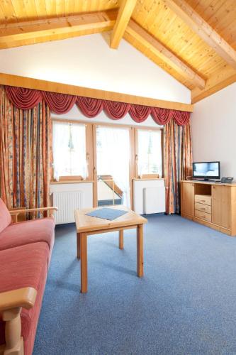 a living room with a couch and a table at Mallaun Hotel.Erlebnis in See