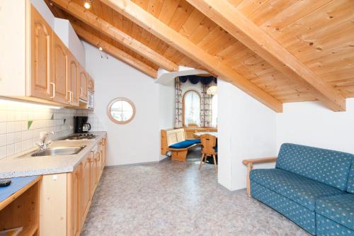 a kitchen with a blue couch and a table at Mallaun Hotel.Erlebnis in See