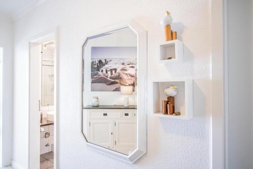 a white bathroom with a mirror on the wall at App. Hegger Inselglück in Westerland (Sylt)