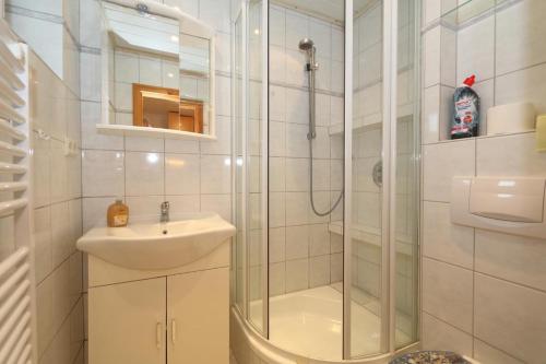 ein Bad mit einer Dusche und einem Waschbecken in der Unterkunft Solveig Fynn 04 in Westerland