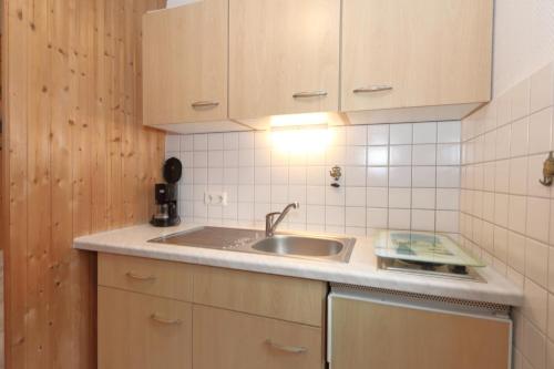 eine Küche mit einer Spüle und Holzschränken in der Unterkunft Solveig Fynn 04 in Westerland