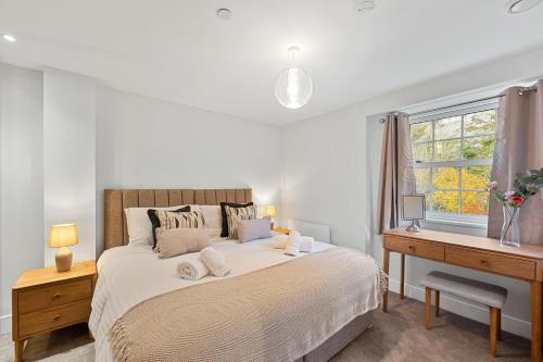 Schlafzimmer mit einem Bett, einem Schreibtisch und einem Fenster in der Unterkunft Cavendish 37 in Tideswell