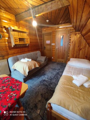 a bedroom with two beds and a couch in a cabin at Chata in Zakopane