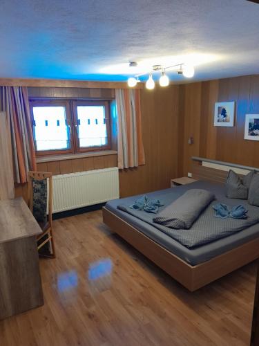 ein Schlafzimmer mit einem großen Bett und zwei Fenstern in der Unterkunft Ferienhof Bichlhof in Arzl im Pitztal