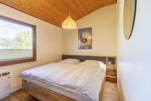 Schlafzimmer mit einem Bett und einem Fenster in der Unterkunft Yin Yang in Simonsberg