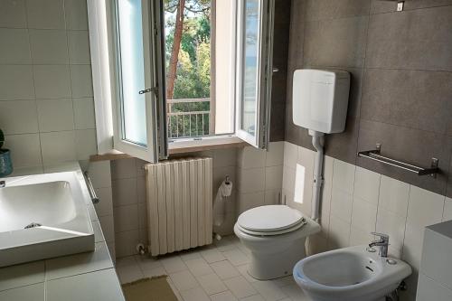 a bathroom with a toilet and a sink and a window at Bea&Berto - B&B - in Trebbiantico