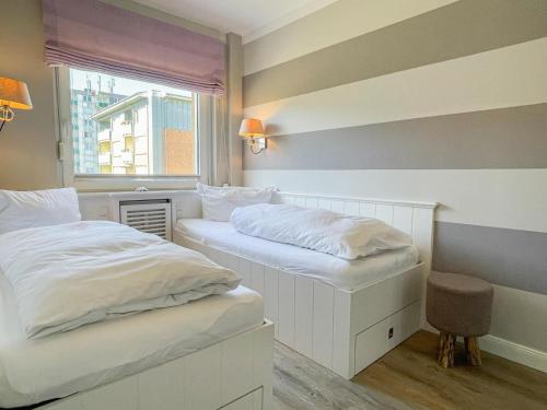 two white beds in a room with a window at App. Theo 50 in Westerland
