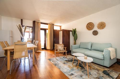 ein Wohnzimmer mit einem blauen Sofa und einem Tisch in der Unterkunft Akisol Troia Pearl in Troia