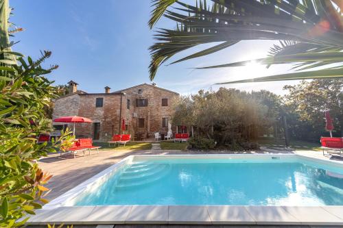 una casa con piscina di fronte a un edificio di Agriturismo Corte Decia a Saludecio