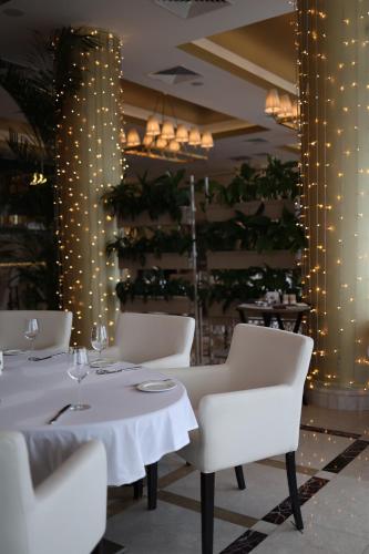 a dining room with white tables and chairs and lights at KADORR Hotel Resort & Spa in Odesa