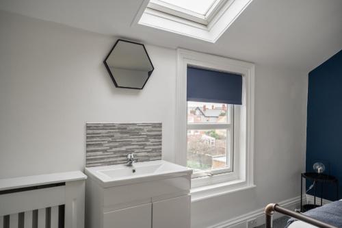 a bathroom with a sink and a window at Grange House by Horizon Stays in Hartlepool