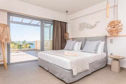 een slaapkamer met een groot bed en een balkon bij 8MOONS Elegant Apartments in Kokkari