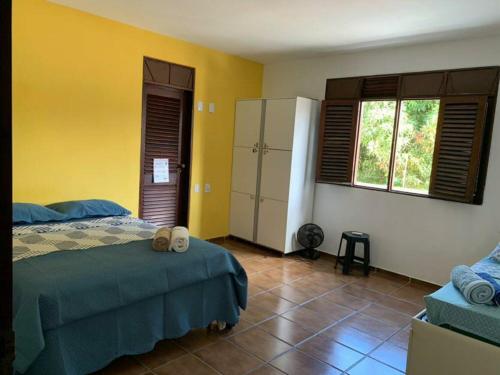 a bedroom with a bed and a yellow wall at Slow Hostel - Hospedagem Criativa in João Pessoa