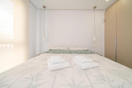 ein Schlafzimmer mit einem großen Bett mit Handtüchern darauf in der Unterkunft Bonifacio in Villacosta