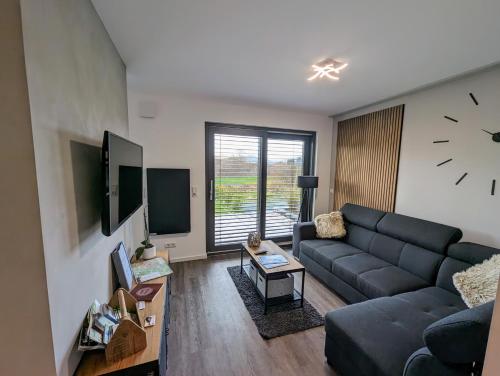 a living room with a couch and a clock on the wall at Bergkultur Sauerland in Medebach