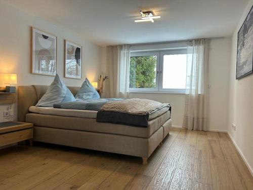 a bedroom with a large bed with a window at Alpinsuite - modern - elegant in Waltenhofen