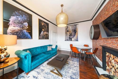 a living room with a blue couch and a fireplace at Central Apartment - Industrial in Blairgowrie