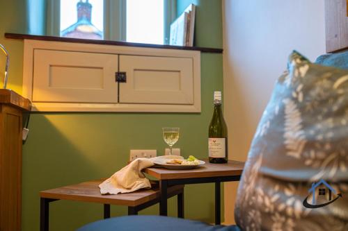 a table with a plate of food and a bottle of wine at Stanwick Studio, cosy country studio, sleeps 4, parking, wifi in Stanwick